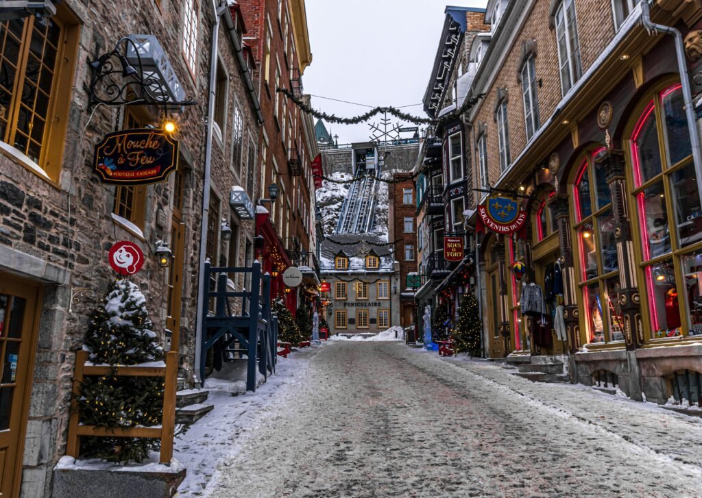 A picturesque winter scene in Old Québec City, showcasing historic buildings and festive decorations on snowy streets.