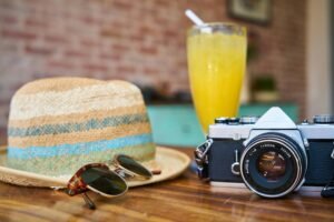 A camera, juice, a sunglass and a hat