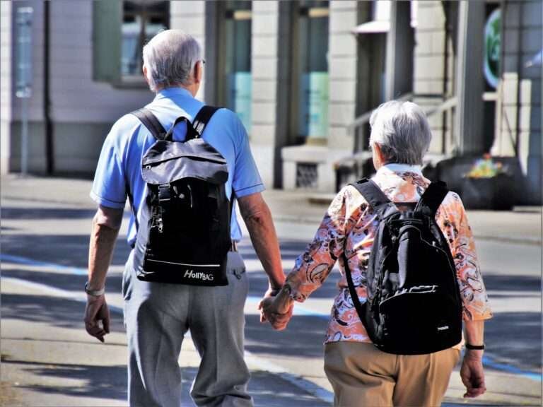 an elderly couple is walking on the road.