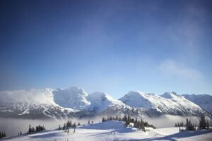 Breathtaking view of snowy mountains and clear sky in Whistler, Canada. Ideal for winter-themed visuals.