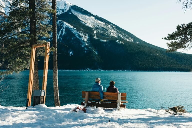 Cozy moment in Banff, Canada with a snowy lake and stunning mountain backdrop.