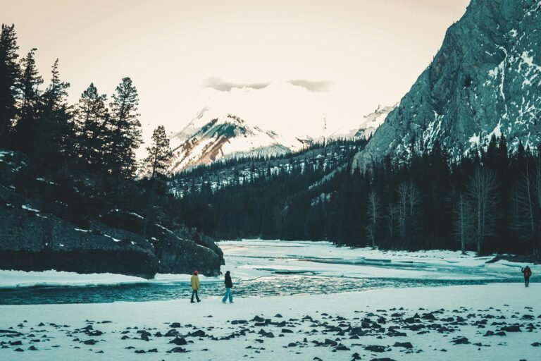 People Hiking along Mountain River in Winter
