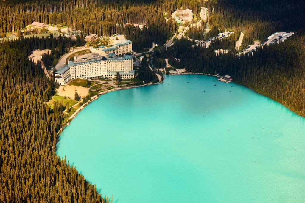 Stunning aerial view of Lake Louise and Fairmont Chateau among lush forests.